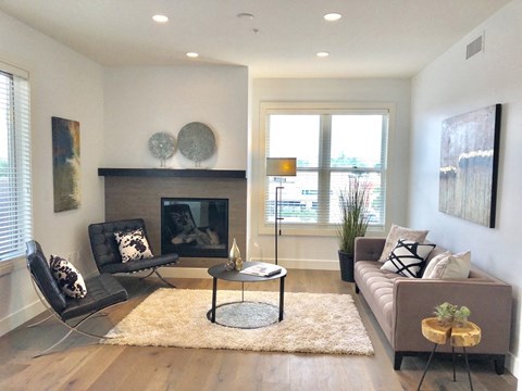 a living room with a couch and two chairs in front of a fireplace